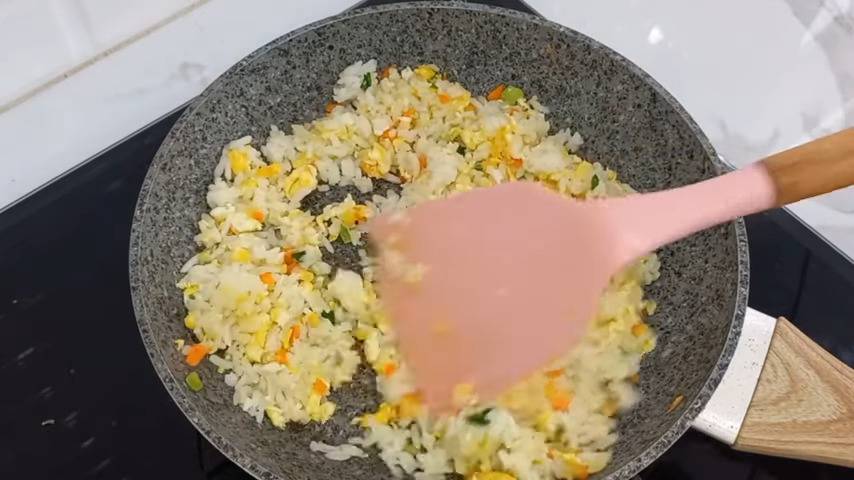 Wajan yang berisi nasi goreng mentega yang sedang dimasak